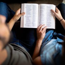 couple reading book on couch